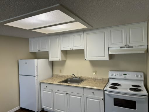 a kitchen with white appliances and white cabinets