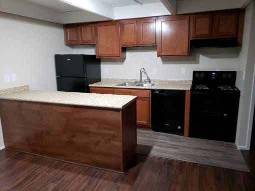 a kitchen with wooden cabinets and black appliances