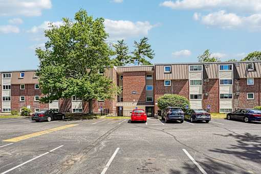 A parking lot with cars and apartment buildings in the background.