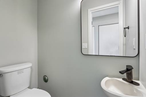 A white toilet sits next to a sink in a bathroom.