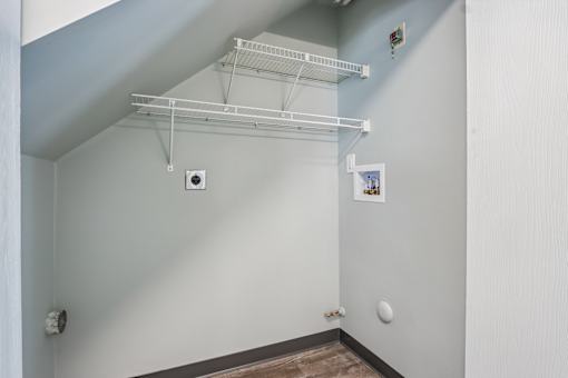 A white wall with a shelf and a small picture on it.