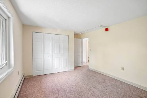 A room with a white door and a red light on the wall.