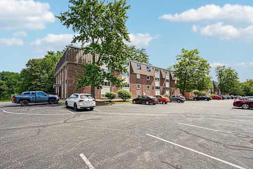 A parking lot with cars and a building in the background.