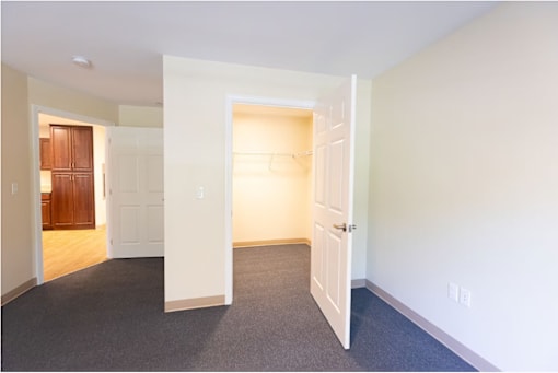 A room with a carpeted floor and two open doors.