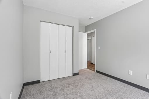 A room with a carpeted floor and a white door.