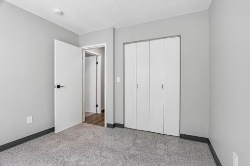 A room with a white door, a white wall, and a white cabinet.