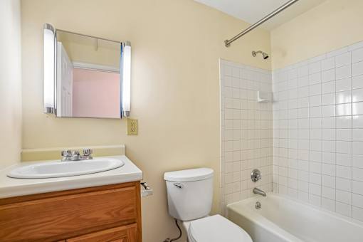 A bathroom with a toilet, sink, and bathtub.
