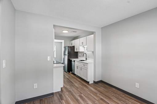 A kitchen with white cabinets and a sink.