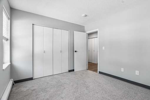 A room with a carpeted floor and a white door.
