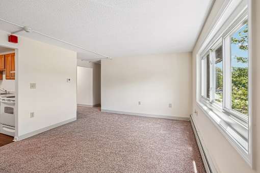 A large empty room with a window on the right side.