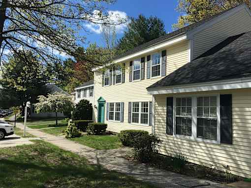 A house with a green door and white siding is shown.