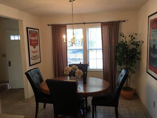 A dining room with a table and chairs.