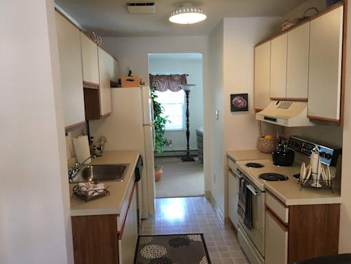 A kitchen with white cabinets and a black stove top.