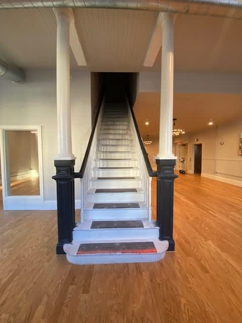A staircase with a white railing and black steps.