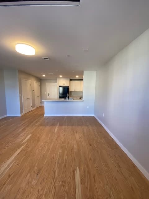 A room with wooden flooring and white walls.