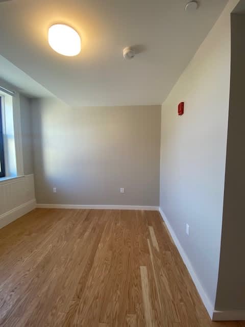 A room with a wooden floor and a window.