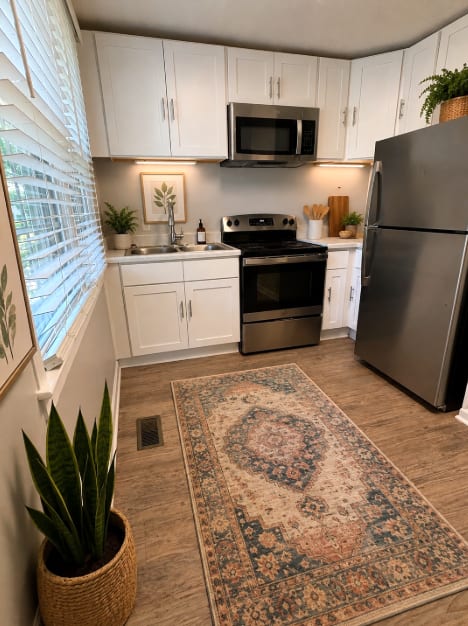 A kitchen with a refrigerator, oven, and sink.