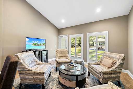 A living room with a television and a view of a lake.