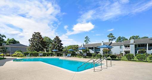 A swimming pool surrounded by a fence and trees.