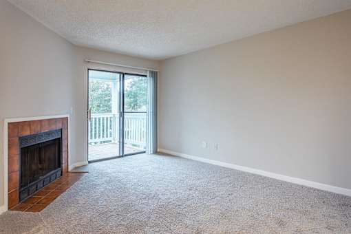 A room with a fireplace and sliding glass doors.