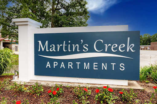 A sign for Martin's Creek Apartments is shown in front of a building.