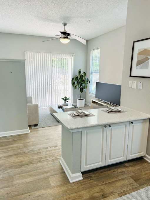 A kitchen with a white counter and a ceiling fan.