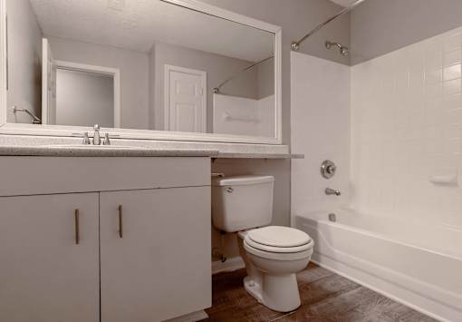 A white bathroom with a toilet, sink, and bathtub.