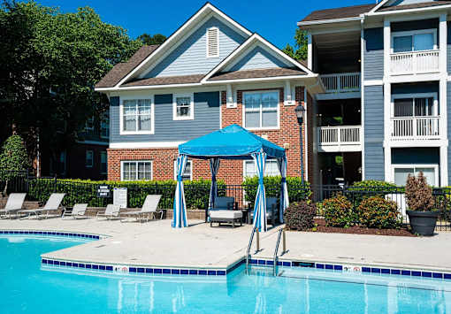 A blue umbrella is next to a swimming pool.