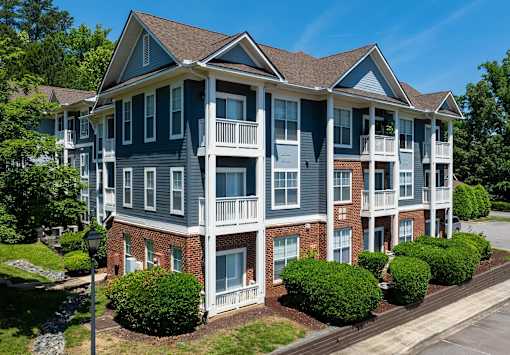 A large apartment building with multiple balconies and a brick facade.