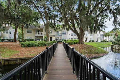 A wooden walkway leads to a row of houses.