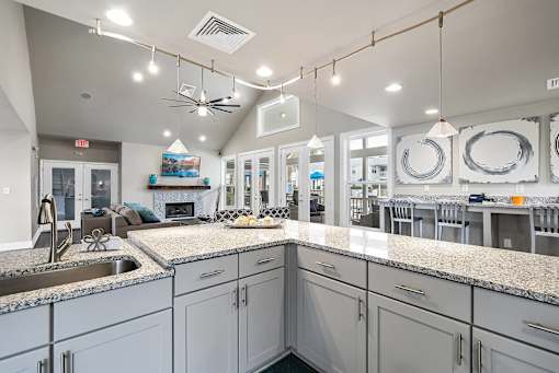 A kitchen with a granite countertop and a ceiling fan.
