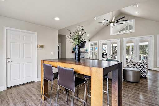 A modern kitchen with a wooden island and bar stools.