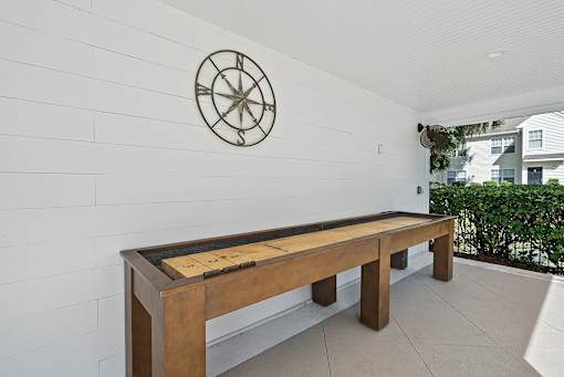 A long wooden table with a compass on the wall.