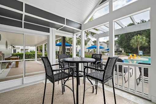 A table with four chairs is on a patio.