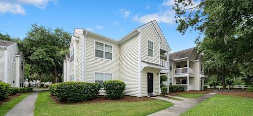 A white two-story house with a black door and windows.