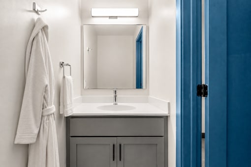 A bathroom with a white sink and a white towel hanging on the wall.