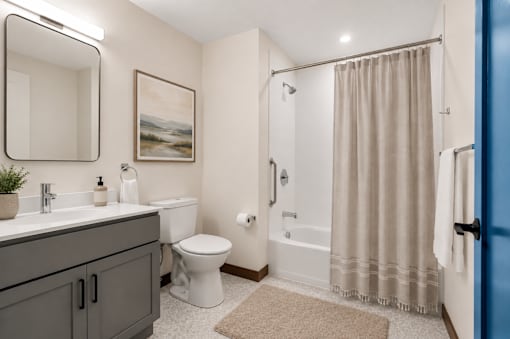 A bathroom with a toilet, sink, and shower.