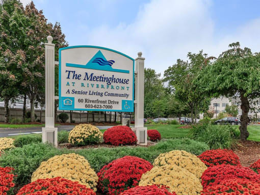 the neighborhood at riverfront sign in front of flowers