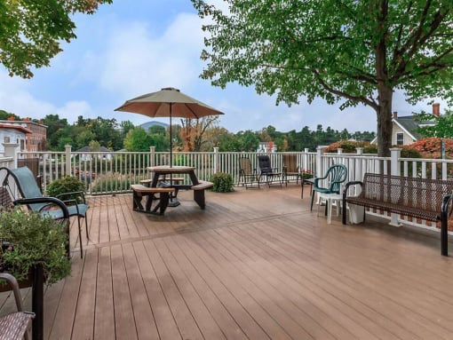 a deck with a table and chairs and a umbrella