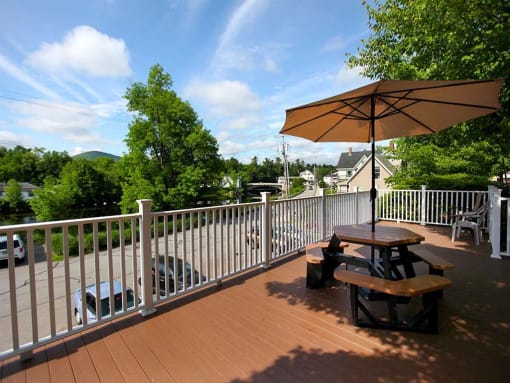 the deck has a picnic table and an umbrella on it