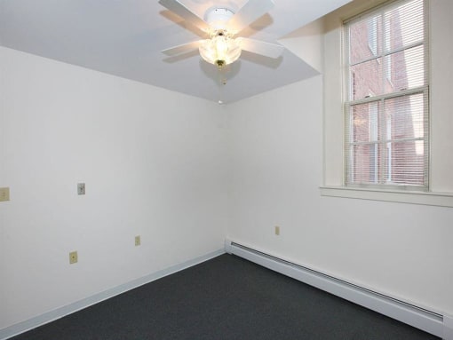 a white room with a ceiling fan and a window