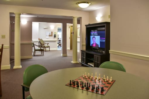 a living room with a chess board and a tv