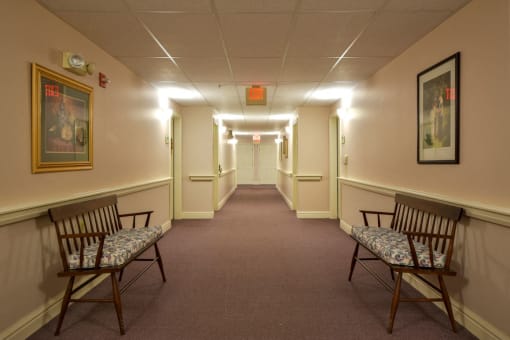 a long corridor with chairs in a hall way