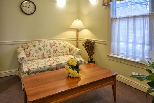 a living room with a couch and a table with flowers
