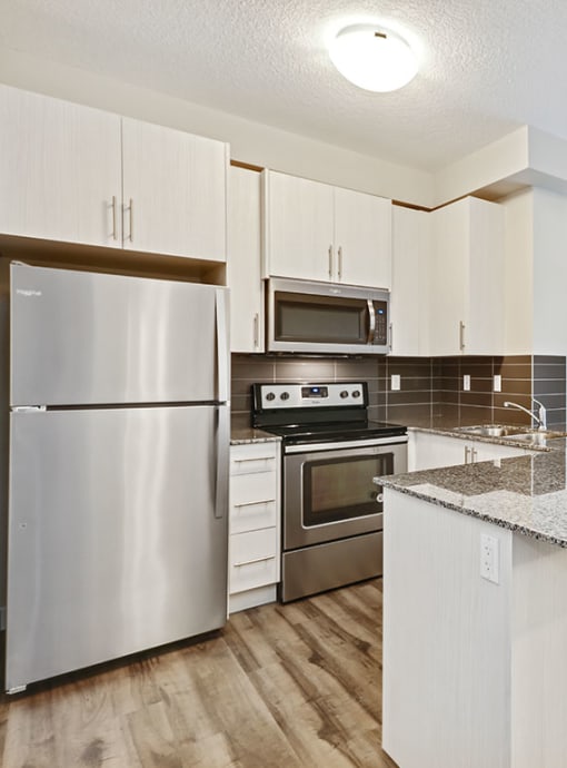 a kitchen with stainless steel appliances and white cabinets