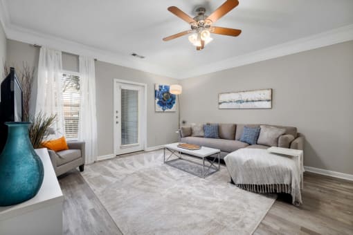 a living room with grey walls and a ceiling fan