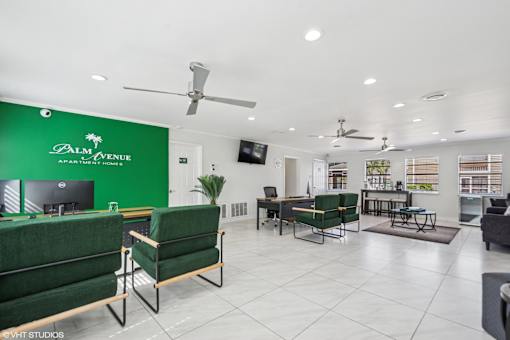 A living room with a green couch and a green chair.