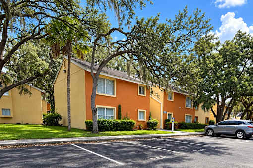 A row of houses with trees in front.