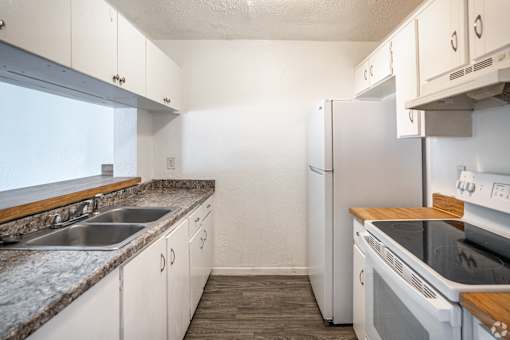 A kitchen with white appliances and wooden countertops.
