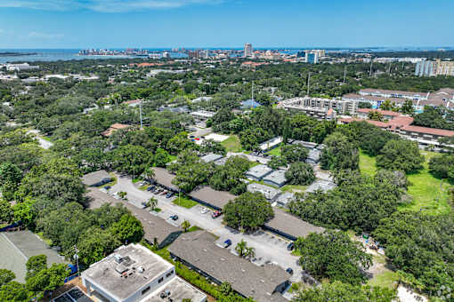 A bird's eye view of a residential area with a tennis court and apartment buildings.